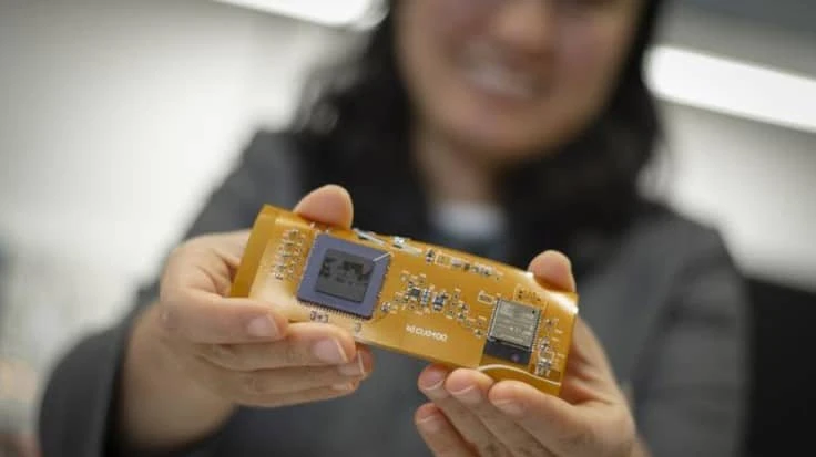 Professor Ulkuhan Guler shows off an early prototype of the miniaturized, wearable device that will one day monitor infants' blood oxygen levels.