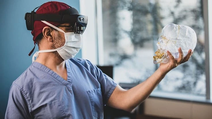 OU Health plastic and reconstructive surgeon Dr. Christian El Amm holds a model of a skull as he demonstrates the surgical visualization device that he developed from a collaboration with Mohammad Abdul Mukit of the University of Oklahoma.